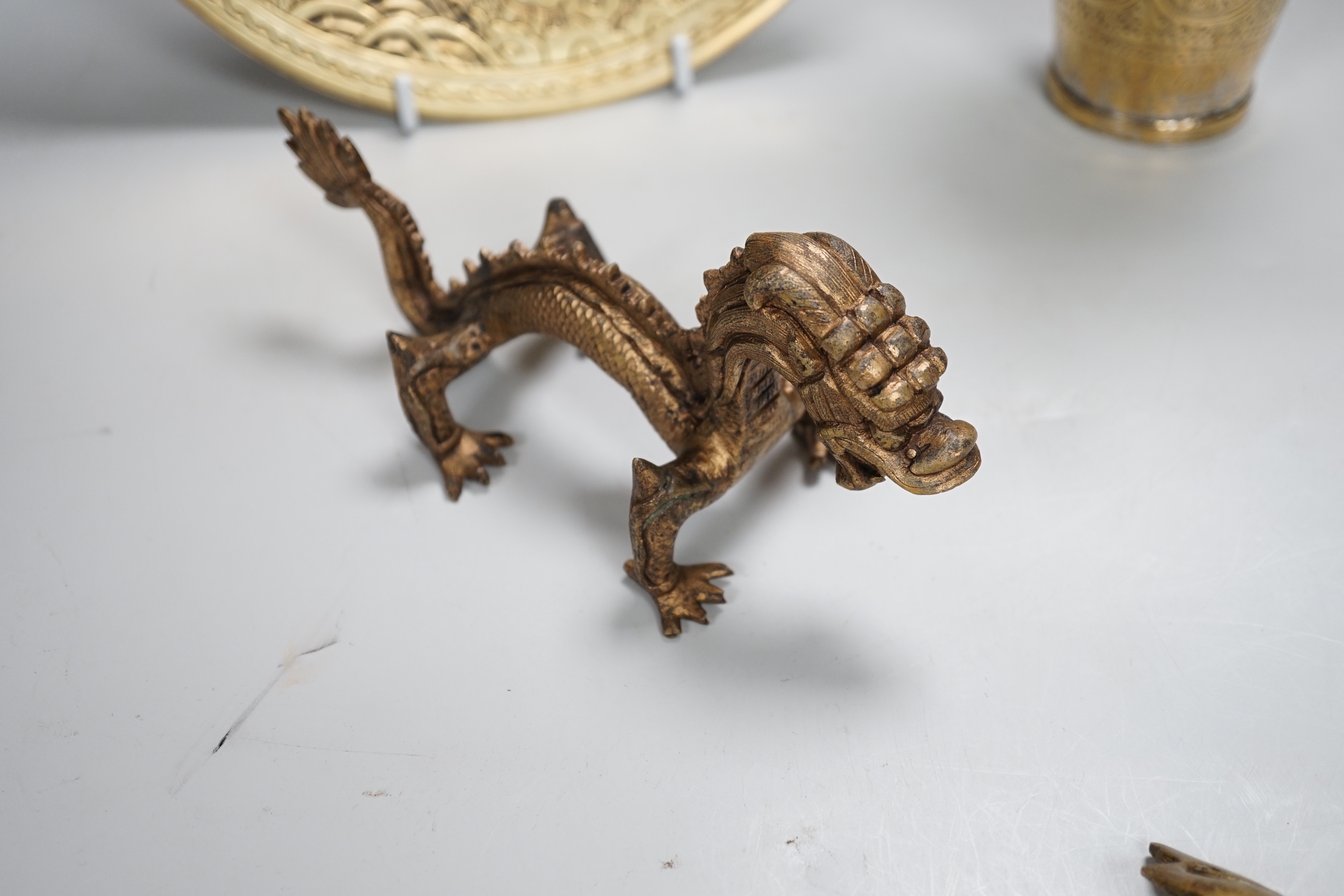 A Chinese engraved brass plate, large engraved beaker, koi fish and a dragon, the largest 24cm in diameter